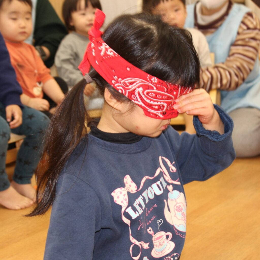 くじら保育園 都島東野田園のお正月遊びで福笑いを楽しむ園児