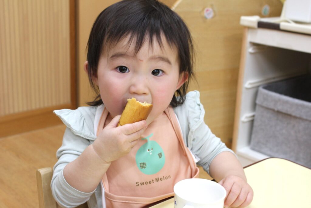 くじら保育園 都島東野田園で、朝のおやつを食べて過ごす園児たち